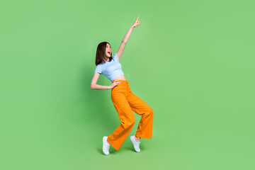 Wall Mural - Full size photo of crazy positive girl raise hand point finger enjoy dancing isolated on green color background