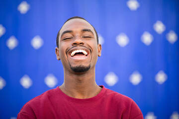 Cheerful young african man smiling against blue background