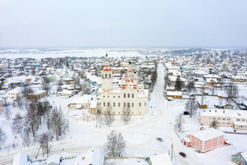 Wall Mural - Panorama of a small city in the depths of Russia from a height. Orthodox churches and traditional old wooden houses, Totma in the Vologda region and a winter view of the city