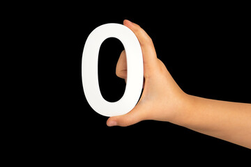 Fototapete - Zero in hand. The number zero is clasped in a hand isolated on a black background. Number zero white in a child's hand on a black background.