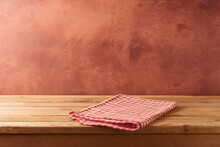 Red checked tablecloth on wooden table over rustic wall  background. Kitchen interior mock up for design and product display