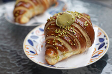 Big Tasty And Delicious Croissant With Pistachio Cream Filling On Plate