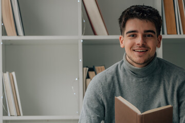 Wall Mural - young man at home reading a textbook