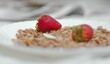 Selective focus of oats with strawberries in a white plate, breakfast idea