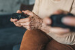 © Strelciuc - Senior woman's hands holding joysticks sitting cozy on the sofa in bright sunny living room. Senior playing console for lifestyle design.