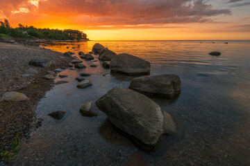 Wall Mural - Wonderful orange sunset on the rocky coast of the sea