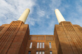 Fototapeta Londyn - Low angle view at chimneys and brick facade of iconic London landmark Battersea Power Station and surrounding area.