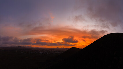 Wall Mural - High level aerial view of the dramatic sunset over the volcanic mountains near Corralejo in Fuerteventura