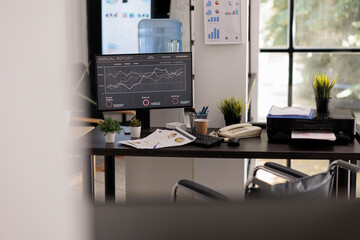 Wall Mural - Interior of illuminated company workspace with desktop computer at the end of the work shift, office wheelchair accessible. Close up view of modern workstation with no people working in it.