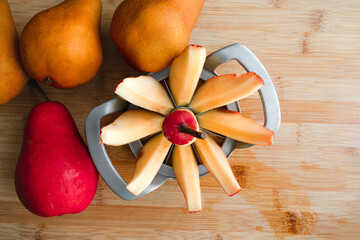 Canvas Print - Coring an Anjou Pear with an Apple Corer and Slicer: Coring an unpeeled red pear on a bamboo wood cutting board