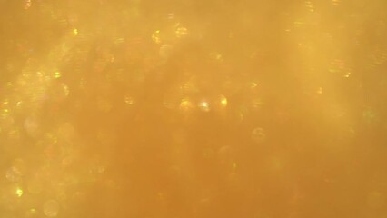 Wall Mural - A movement of gold dust particles bokeh. Shimmering little cool bokeh on a golden background. Chaotic movement of moving shiny glitters . Gold flying bokeh particles abstract background. 