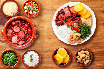 Brazilian feijoada, traditional food from Brazil cuisine, on white plate, over rustic wooden table