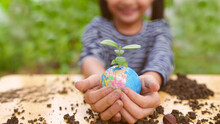 Banner Of Blurred  Little Girl Is Holding Plant And Globe Model Together, Concept Of ESG, Environment, Earth Day, Sustainability, World Environment Day, Montessori Education For Kid And Home School.