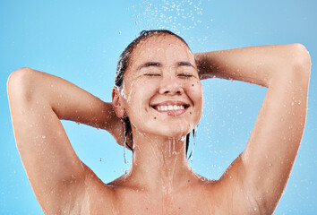 Canvas Print - Shower, skincare and woman in studio for cleaning, wellness and beauty water splash blue mockup. Happy, young and hygiene asian model with water drops in bathroom for face skin care morning routine