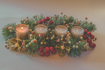 Wall Mural - first advent candle burning on decorated green golden red advent wreath