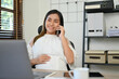 © bongkarn - Successful Asian pregnant female boss talking on the phone while touching her belly at her desk.