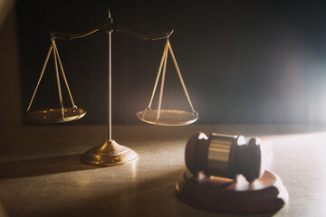 Business and lawyers discussing contract papers with brass scale on desk in office. Law, legal services, advice, justice and law concept picture with film grain effect