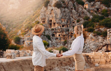 Happy Lover Couple Tourist Archaeologist In Hat Background Old Tomb Myra Ancient City In Demre To Antalya, Archaeology Of Turkey