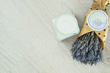 Handmade cosmetic cream jar and dried lavender flowers in light background. Bio organic cosmetics. Plant base.