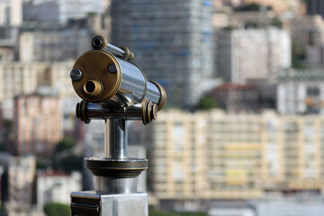 Monaco, Monaco - 02.10.2022: Morning view of the Principality of Monaco from the Prince's palace, with a telescope in the foreground, partly out of focus