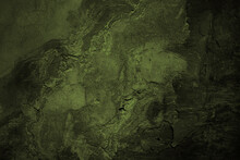 Brown Green Concrete Wall Surface. Dark Olive Color. Close-up. Rough Background For Design. Distressed, Cracked, Broken, Crumbled.