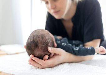 Wall Mural - Loving mother carries in hands little head of her newborn baby child