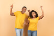 Excited young black couple dancing and enjoying favourite music, fooling around and having fun together