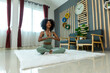 © kanpisut - Woman doing yoga at home in the living room. Woman is stretching in yoga at home. work out time