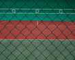 Geometryczne kształty kortu tenisowego widziane zza siatki