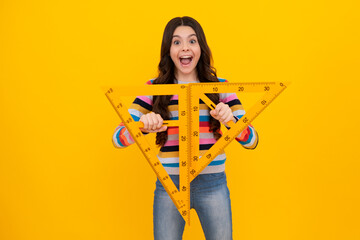 Poster - Amazed teenager. Measuring school equipment. Schoolgirl holding measure for geometry lesson, isolated on yellow background. Student study math. Excited teen girl.