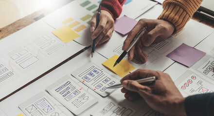 UI UX creative designer team designing wireframe layout for responsive mobile smartphone application in office