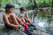 Children Putting On Socks And Shoes After Swimming