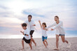 © Kiattisak - Happy asian family enjoy the sea beach at consisting father, mother,son and daughter having fun playing beach in summer vacation on the ocean beach. Happy family with vacations time lifestyle concept.
