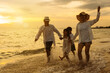 Happy asian family enjoy the sea beach at consisting father, mother,son and daughter having fun playing beach in summer vacation on the ocean beach. Happy family with vacations time lifestyle concept.