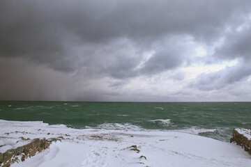 Stormy sea and snowy landscape