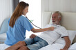 © Thitiporn - Caring nurse with senior man sitting in the bedroom . caucasian man. Discussing. Caring caregiver and senior citizen. Nurse helping senior patient . Young nurse helping elderly man