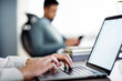 © Cavan Images - Cropped image of businessman using laptop in creative office