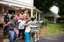 Female Soldier Embracing Family And Friends