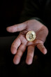 Hand holding and showing a golden Bitcoin,