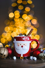 Hot Cocoa In Santa Mug With Christmas Tree Lights In The Background.