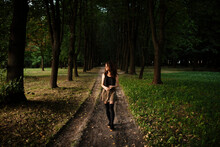 Woman Walking On A Dirt Road In The Park