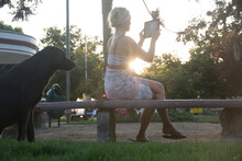 Woman Takes Pic With Digital Tablet In Park, At Sunrise