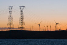 Wind Turbines And Power Transmission Lines At Sunset Near San Francisco