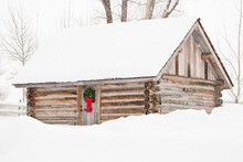 A Snow Covered Log Cabin Is Decorated For Christmas In Jackson Hole, Wyoming.
