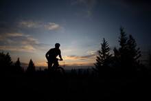 A Mountain Biker Silhouetted At Sunset On The Top Of Blue Mountain.