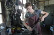 © Cavan Images - Blacksmith apprentice rasping iron fixed in plain vise