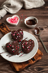 Wall Mural - Dessert for Valentine's Day. Homemade heart shaped chocolate cupcakes on a dark wooden table. Chocolate muffins in the shape of a heart. Cooking with love concept.