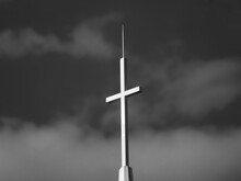 Black And White Church Cross Against A Cloudy Sky, Featuring A Lighting Rod.