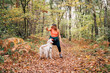 © Daniel Gonzalez/Stocksy - A beautiful woman has fun with her dog in autumn
