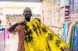 © Daniel Gonzalez/Stocksy - Black man folding bright fabric